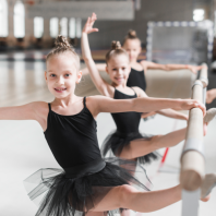 niñas en la barra haciendo danza clasica